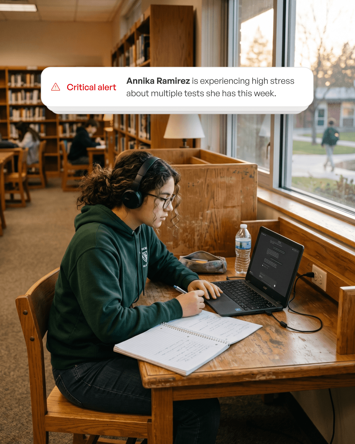 Student working in a library with a critical alert notification visible to their teacher