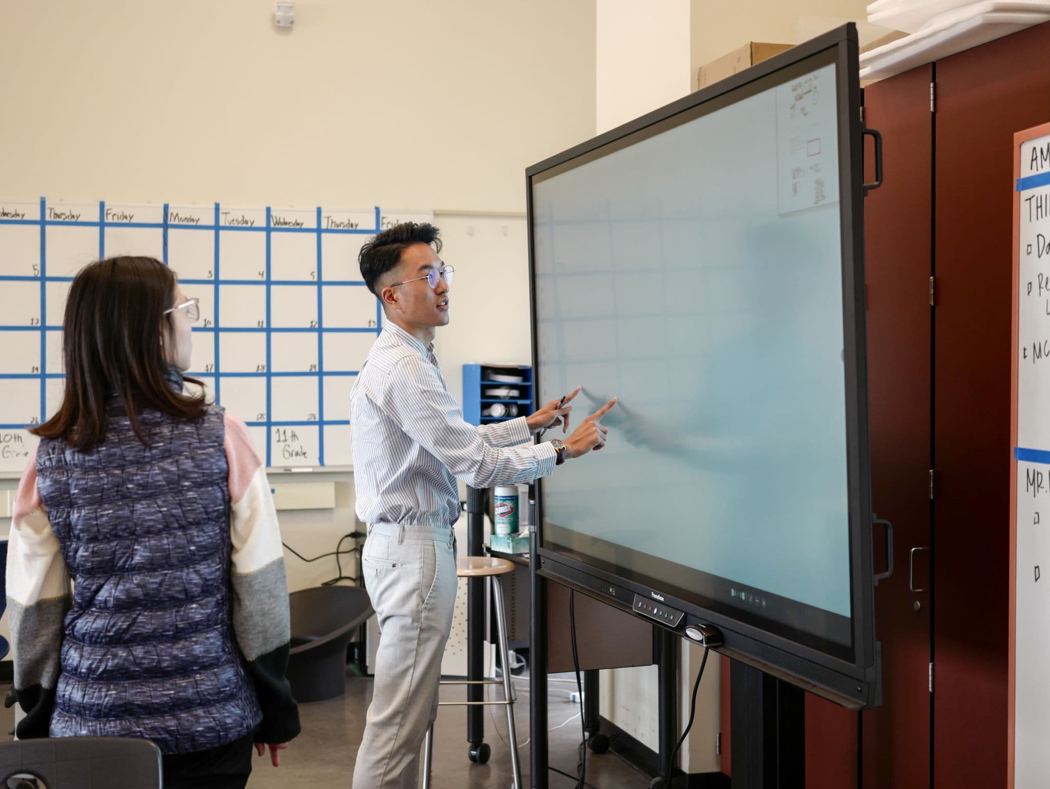 Educator presenting at a smartboard during a professional learning session